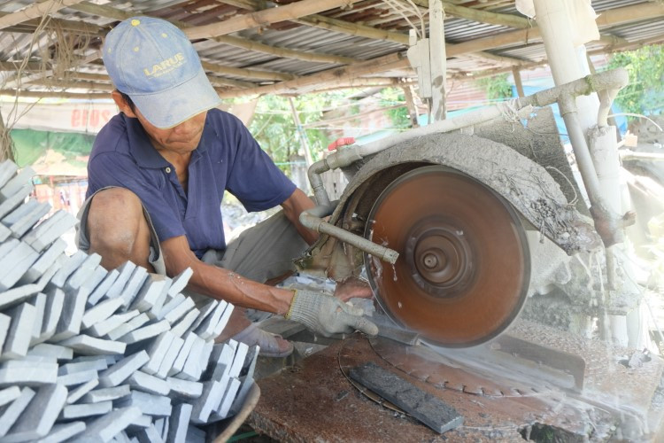 Anh Dũng đang xẻ đá ra theo quy cách. Anh Dũng đang xẻ đá ra theo quy cách.
