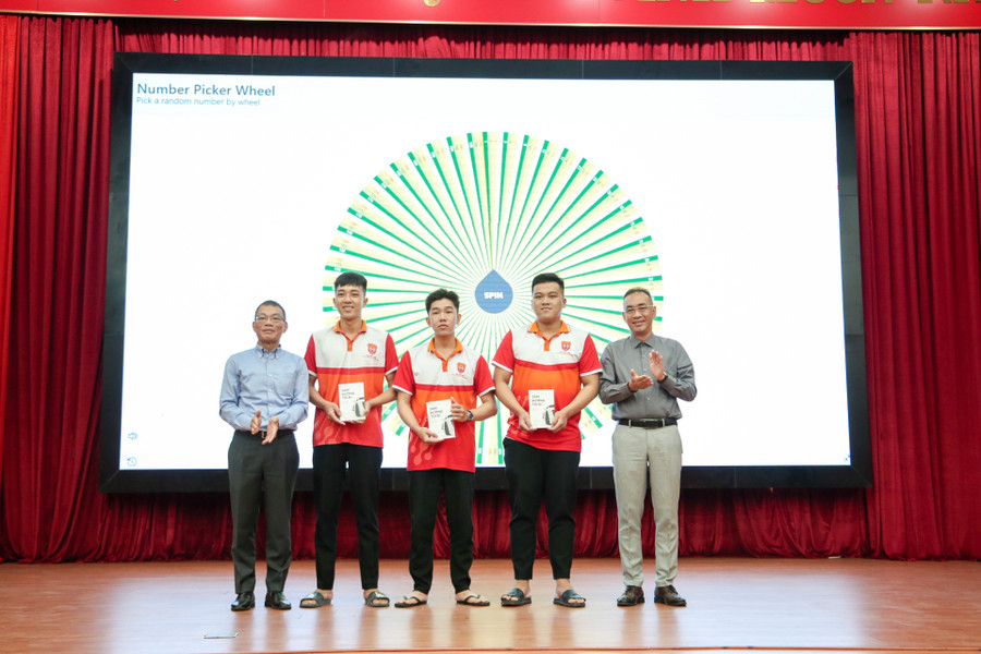 Ông Võ Quang Huệ trao tặng sách tự truyện “Dặm đường tôi đi: hành trình từ BMW, Bosch đến Vinfast” cho sinh viên.