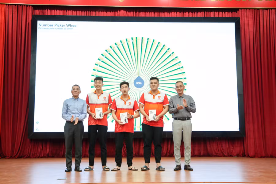 Ông Võ Quang Huệ trao tặng sách tự truyện “Dặm đường tôi đi: hành trình từ BMW, Bosch đến Vinfast” cho sinh viên.