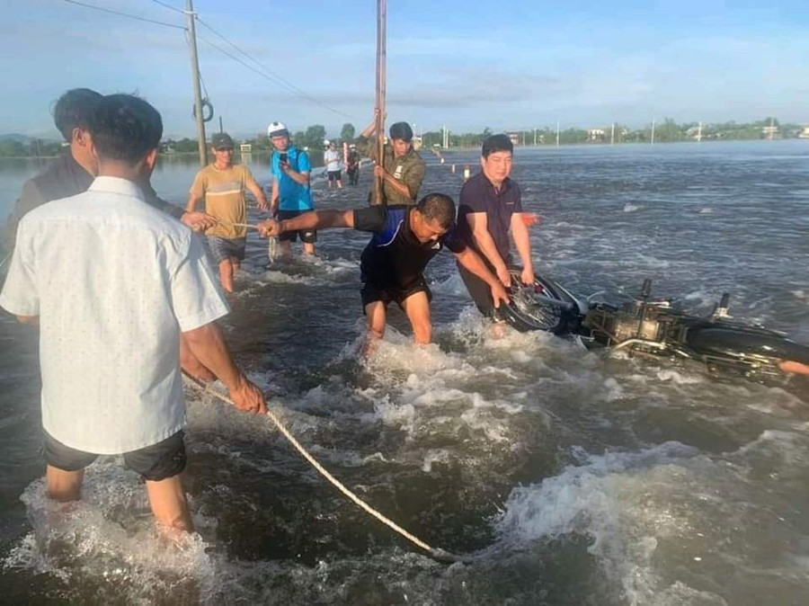 Người dân và lực lượng chức năng kịp thời cứu 2 vợ chồng bị nước cuốn trôi. (Ảnh: V.T)