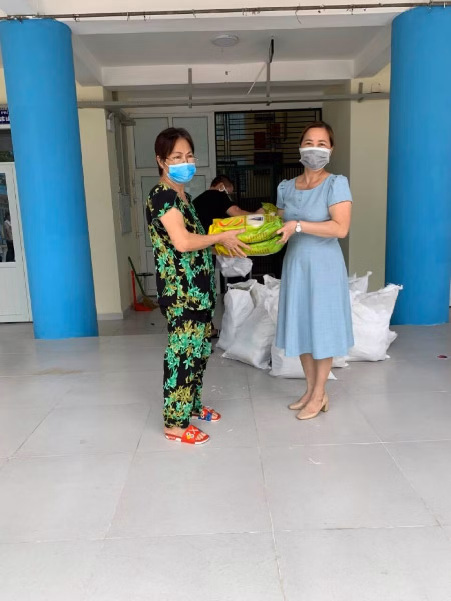 Cô Đinh Phương Anh (phải) trao gạo cho người dân có hoàn cảnh khó khăn phường Bạch Đằng.