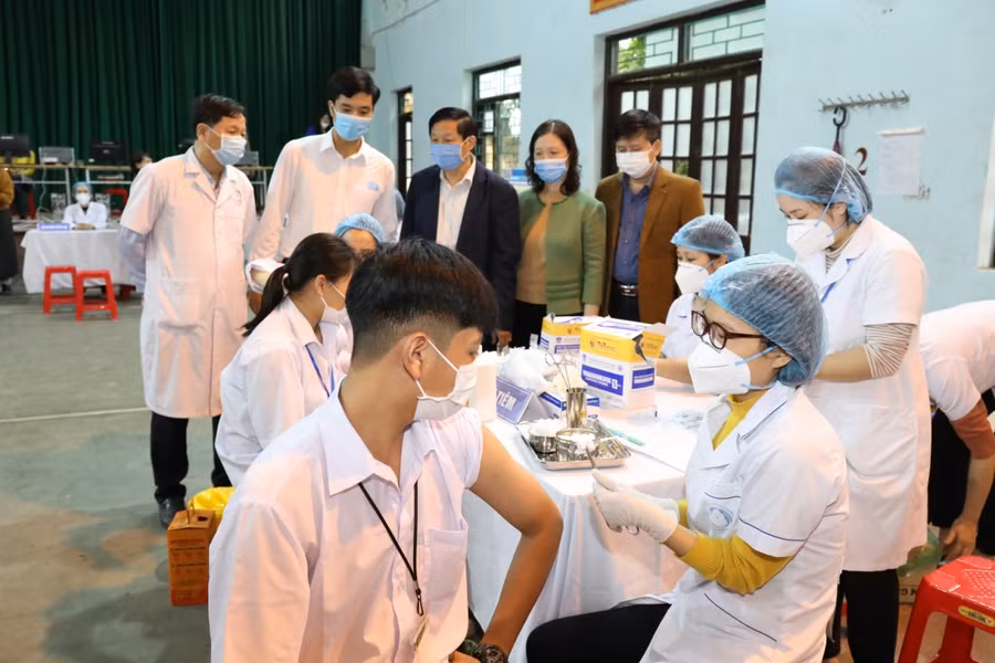 Các đồng chí lãnh đạo Sở Y tế và Giáo dục kiểm tra tại điểm tiêm trường THPT Đinh Tiên Hoàng. Ảnh: Báo Ninh Bình.