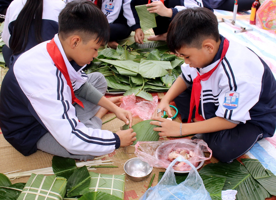 Ở đội này các bạn nữ cắt lá còn đôi bạn nam này "cân" hết công việc gói bánh, quyết tâm tạo nên những chiếc bánh tuyệt phầm nhất cuộc thi.