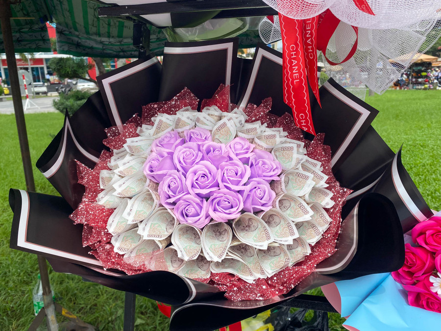 Những bó hoa kết hợp với tờ tiền mệnh giá 2000 đồng thu hút người mua. Những bó hoa kết hợp với tờ tiền mệnh giá 2000 đồng thu hút người mua.