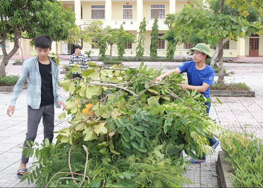 Thầy Quyết (bên phải) cùng học trò dọn vệ sinh sân trường. Thầy Quyết (bên phải) cùng học trò dọn vệ sinh sân trường.