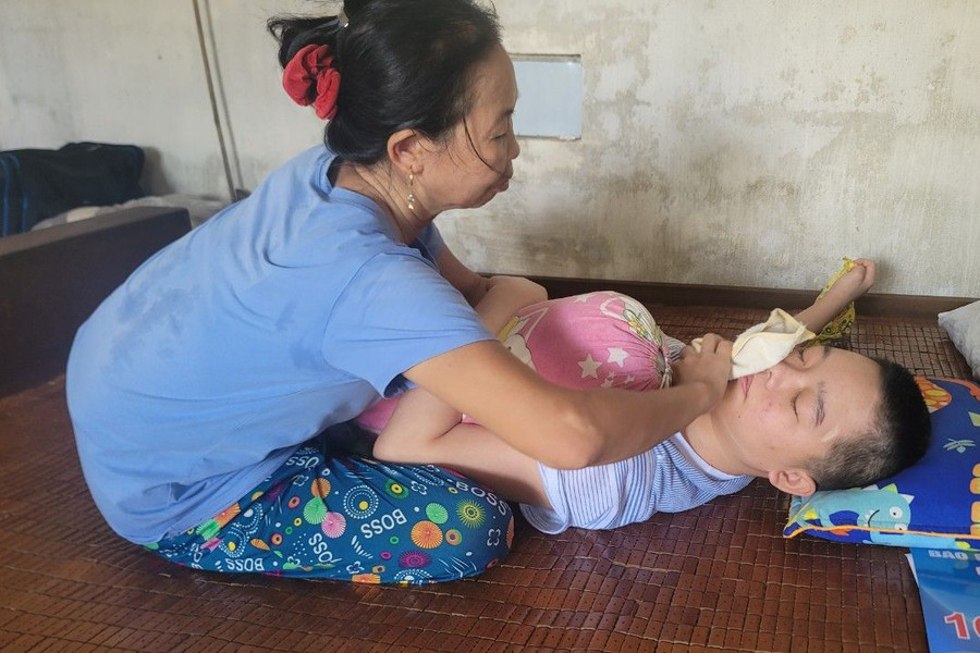 Hàng ngày, chị Bảy phải túc trực bên cạnh để chăm sóc cho con. (Ảnh: Vũ Long)