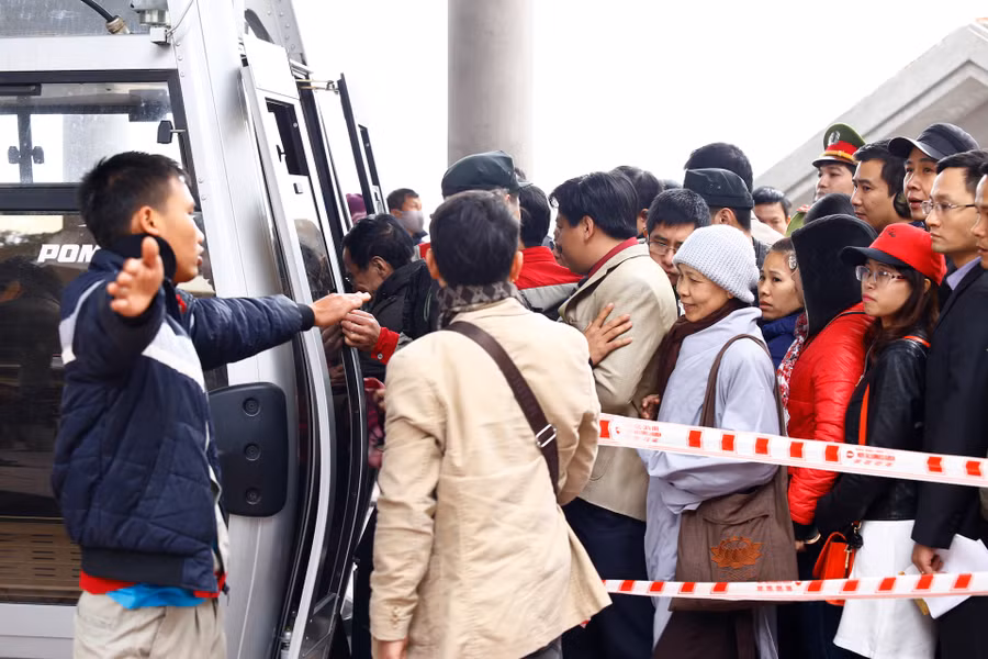 Nhân viên nhà ga làm việc rất vất vả để hạn chế việc quá số lượng người ngồi trên cabin so với quy định.