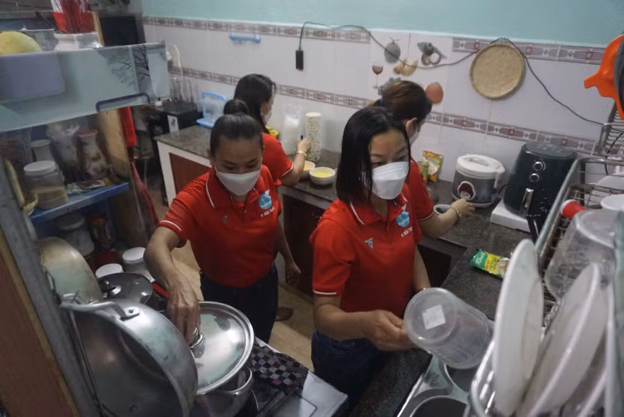 Những thành viên của Chi hội Phụ nữ số 1 tất bật nấu ăn để kịp giờ trao đồ ăn cho người dân nghèo.