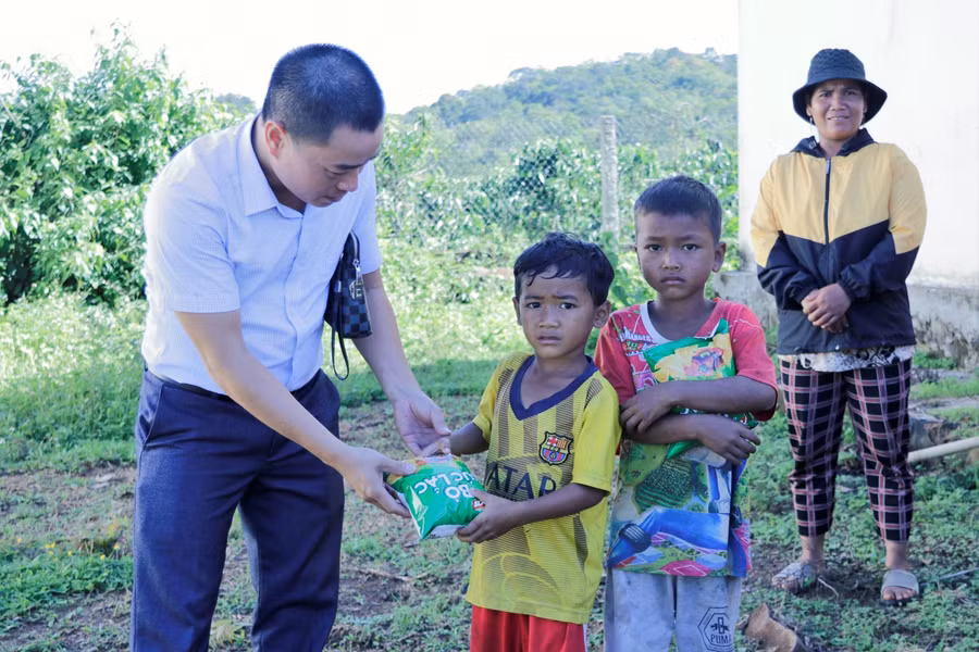 Đoàn công tác tặng quà cho các cháu nhỏ trong buôn Lách Ló tại Lễ khởi công.
