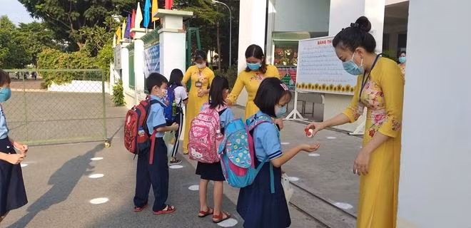 Trẻ được hướng dẫn sát khuẩn tại cổng trường học. Ảnh minh họa.