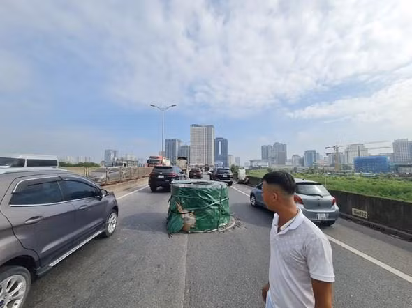 Cuộn thép nặng 21 tấn chắn ngang đường, mặt đường bị cú rơi mạnh làm hư hỏng. Ảnh: Phạm Công.