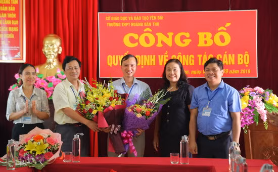 Bà Nguyễn Thị Minh Phương - Phó Bí thư Thường trực huyện ủy Lục Yên (thứ hai, bên phải ảnh) tặng hoa chúc mừng Hiệu trưởng Phạm Văn Thư.