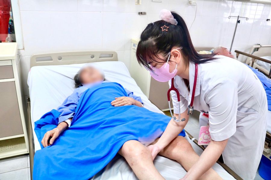 Bác sĩ kiểm tra tình trạng vùng gối 2 bên của bệnh nhân M. Ảnh: TTYT Quảng Yên