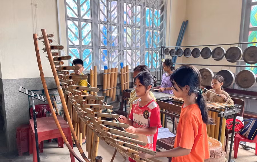 Y Thiên An bất đắc dĩ trở thành giáo viên dạy nhạc cụ dân tộc cho lũ trẻ trong làng.