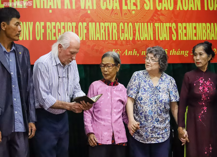 Cựu binh Mỹ Peter Mathews trao trả cuốn nhật ký cho thân nhân liệt sĩ Cao Xuân Tuất. (Ảnh: Tùng Nguyễn).