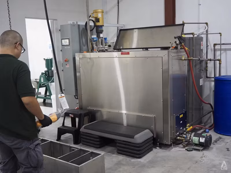 Ông Joe Kam sử dụng máy phân hủy kiềm tại The Green Mortician. Ảnh: CNA/Louisa Tang