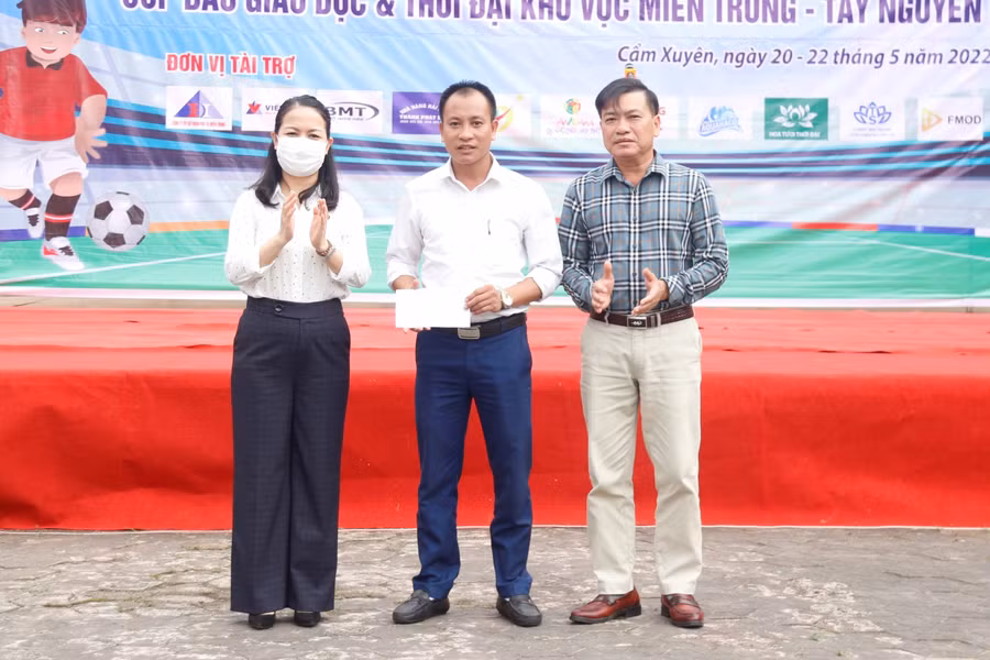 Đại diện báo GD&amp;TĐ khu vực MT-TN trao quà bạn đọc số tiền 22.300.000 đồng đến đại diện của em Nguyễn Huy Chính.