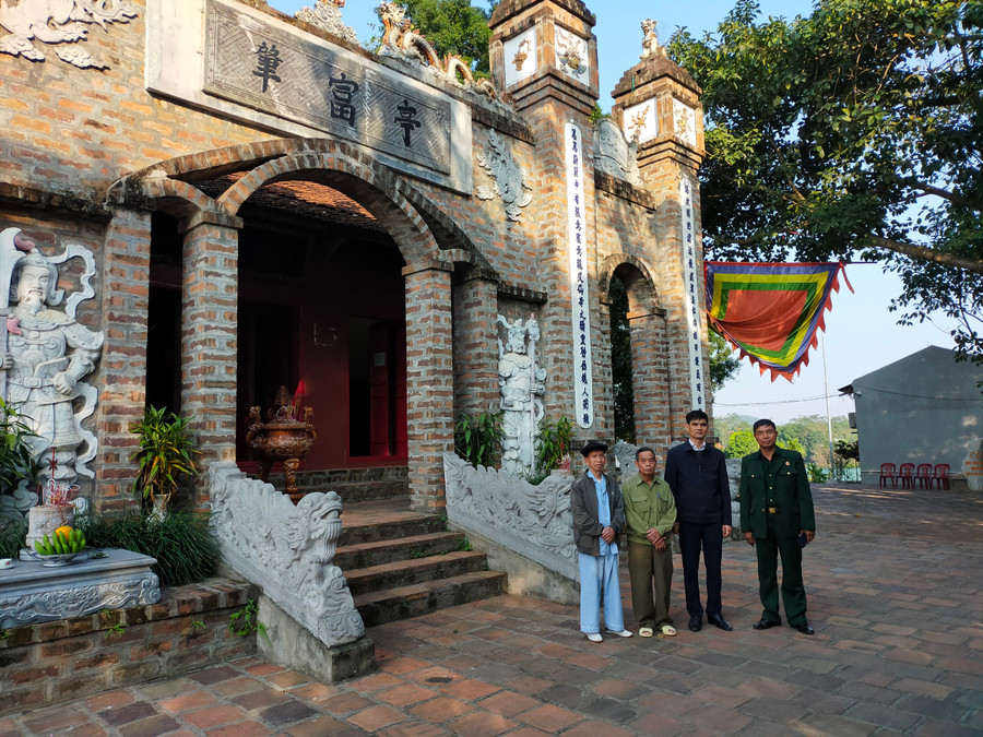 Cụ Tình (ngoài cùng bìa trái) và đại diện chính quyền địa phương giới thiệu về đền Triệu Phú (đền Trẹo).