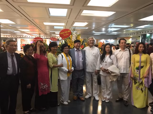 Họa sĩ Ngô Xuân Bính (thứ 5 từ phải sang) chụp ảnh cùng khách mời tham dự triển lãm