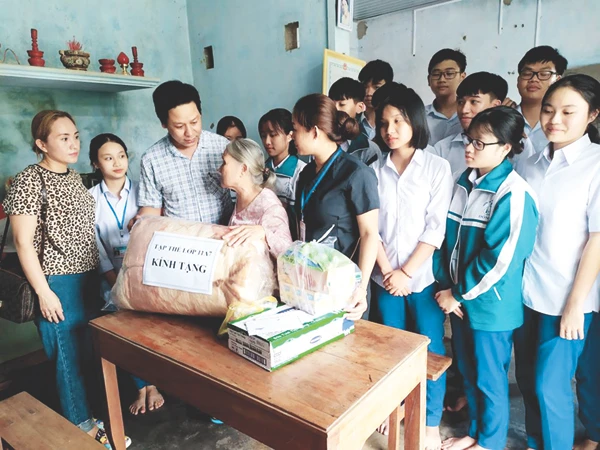 Đại diện Đoàn trường và các em học sinh Chi đoàn 11A7 thăm, tặng quà cho bà Huệ