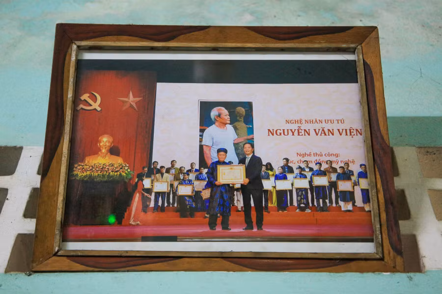 Hàng loạt sản phẩm cùng các Bằng khen, Giấy khen, Giấy chứng nhận được trưng bày tại một góc nhà (ảnh trái) và hình ảnh ông Viện nhận danh hiệu Nghệ nhân Ưu tú được Chủ tịch nước phong tặng (ảnh phải). (Ảnh: Hoàng Hải)