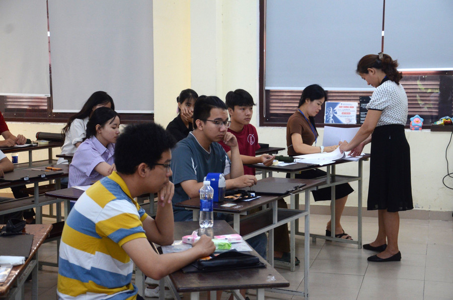 Cán bộ coi thi chuẩn bị phát giấy thi và đề cho thí sinh. Cán bộ coi thi chuẩn bị phát giấy thi và đề cho thí sinh.