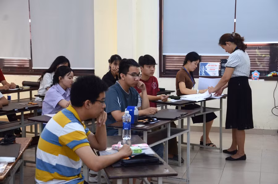 Cán bộ coi thi chuẩn bị phát giấy thi và đề cho thí sinh.