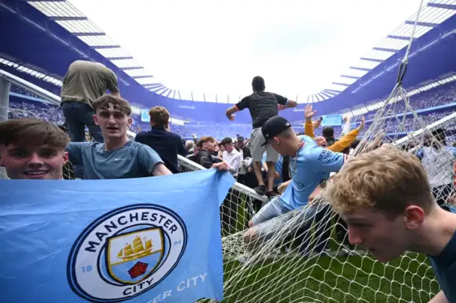 Cổ động viên Man City pháo rào chắn tràn xuống sân Etihad khi đội nhà vô địch Ngoại hạng Anh.
