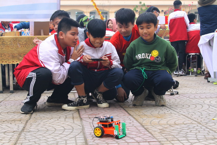 Nhóm bạn này đang trải nghiệm mô hình robot tự hành điều khiển từ xa được các em nghiên cứu, lắp ráp. Ảnh: Việt Hà