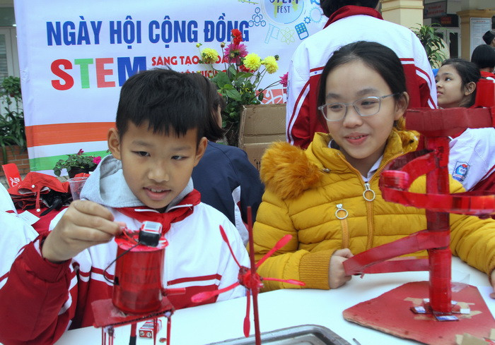 Bạn trai này đang hào hứng thuyết minh nguyên lý hoạt động máy bơm và guồng nước từ những chiếc thìa sữa chua. Ảnh: Việt Hà