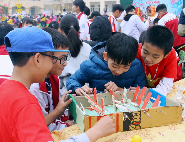 Các bạn nhỏ này đang hào hứng với sân bóng làm từ bìa các tông. Ảnh: Việt Hà