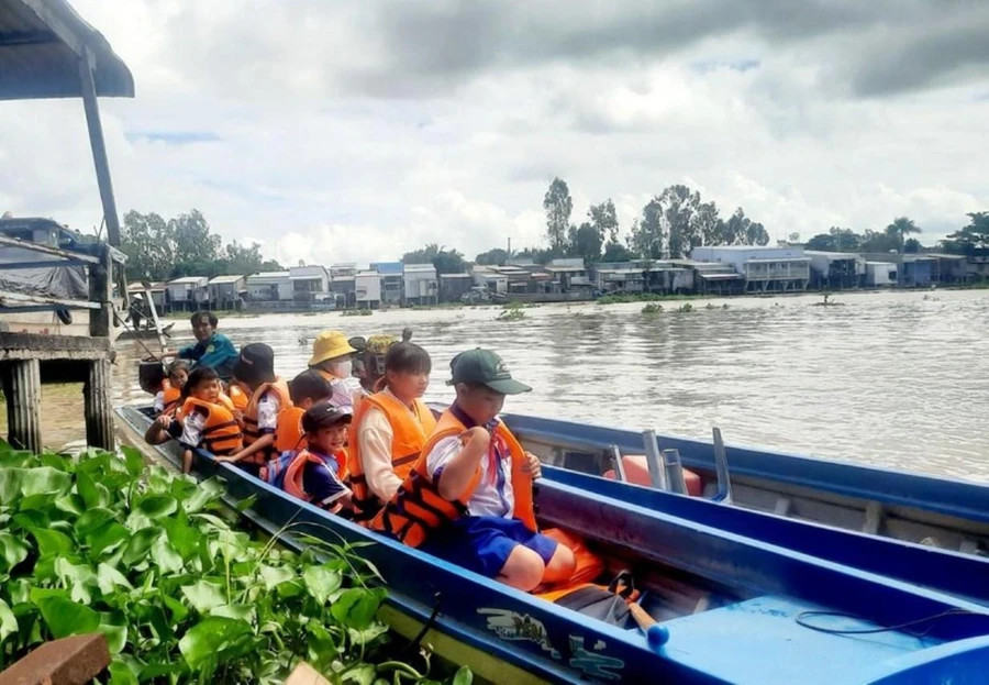 Học sinh vùng lũ huyện An Phú (An Giang) được đưa rước đến trường. Ảnh: T. Nhân