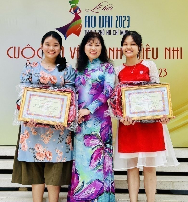 Cô Trần Đoàn Thanh Ngọc cùng 2 học sinh trong buổi trao giải Cuộc thi vẽ tranh thiếu nhi Áo dài và hoa năm 2023 Cô Trần Đoàn Thanh Ngọc cùng 2 học sinh trong buổi trao giải Cuộc thi vẽ tranh thiếu nhi Áo dài và hoa năm 2023