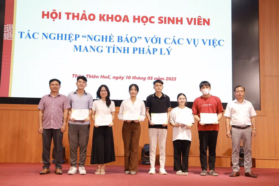 Các đại biểu, khách mời trao giấy chứng nhận cho sinh viên tham gia hội thảo. (Ảnh: Hoàng Hải).