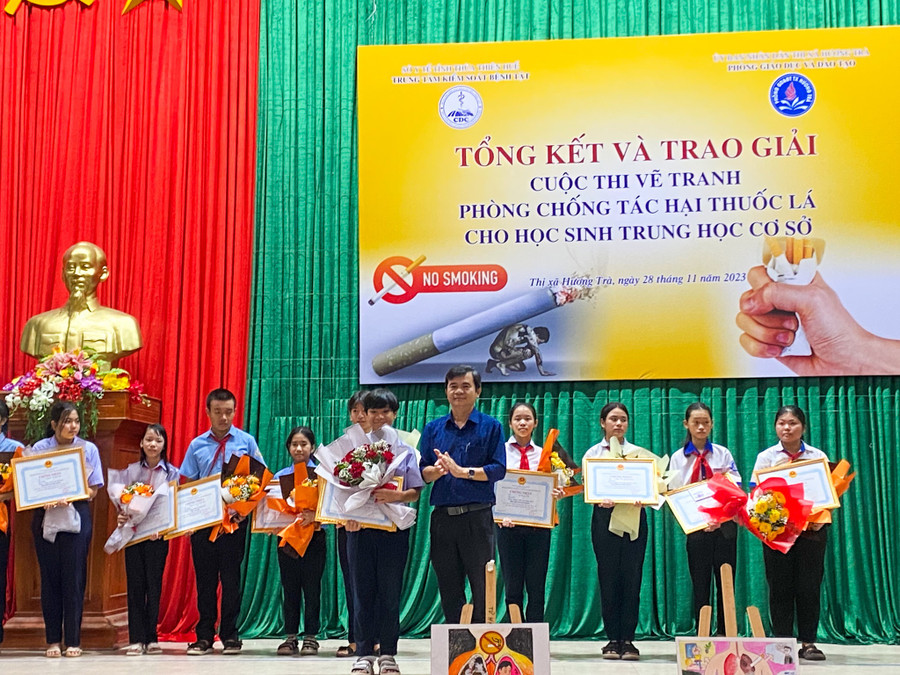 Ban tổ chức tặng hoa và giấy chứng nhận cho học sinh đạt giải Nhất của cuộc thi.