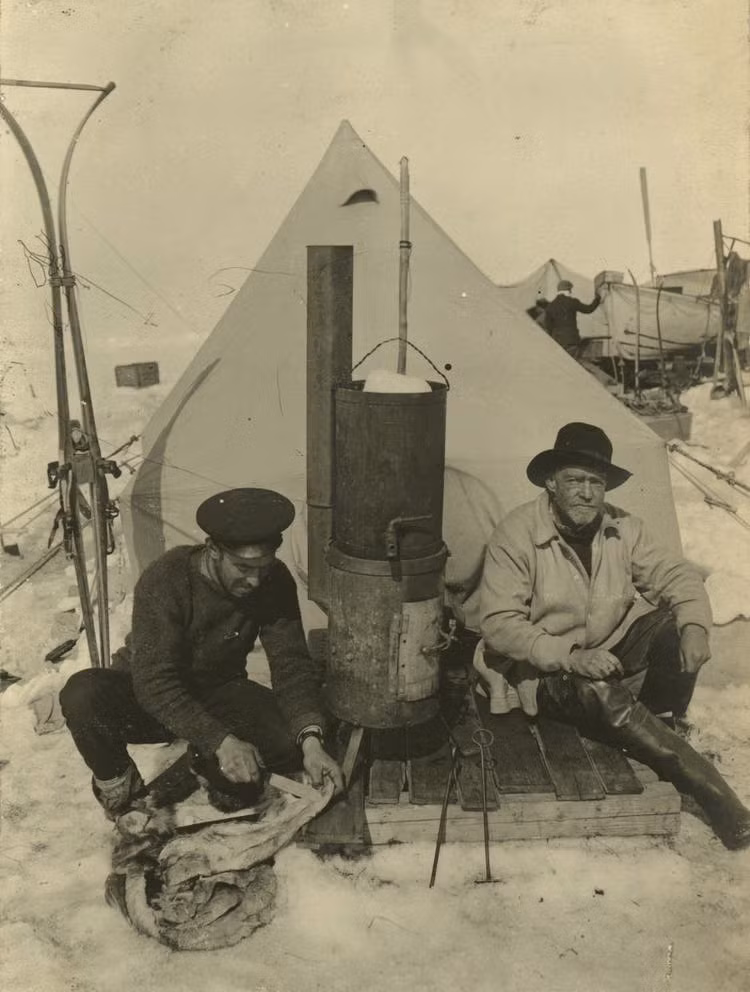Ernest Shackleton (phải) và đồng đội Frank Hurley (trái) nấu ăn trước lều dựng tạm trên băng.