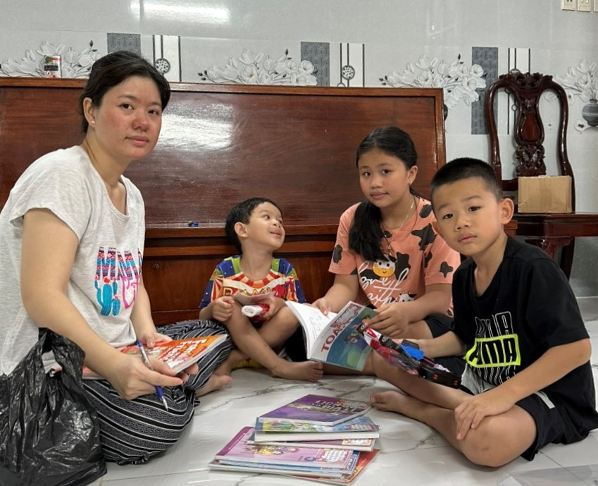 Chị Lâm Tú Nhung và 3 con chuẩn bị sách vở cho năm học mới. Ảnh: NVCC