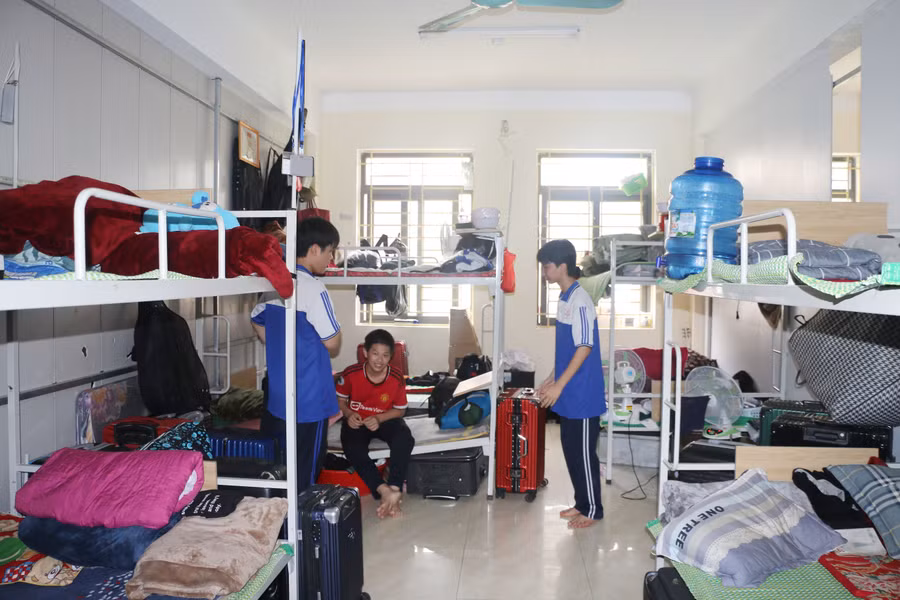 Học sinh nam Trường THPT Dân tộc nội trú tỉnh Nghệ An đang chuyển đến ở tạm tại nhà đa chức năng của trường.
