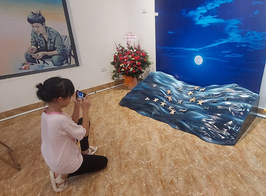 Cô bé Thảo Anh thích thú ghi lại hình ảnh &apos;Bóng đêm&apos; ở triển lãm. Ảnh: Bình Thanh.