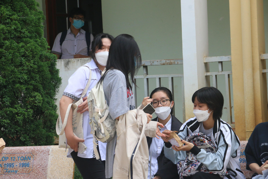 Kết thúc môn thi Ngữ văn, các thí sinh gặp bạn bè ở khuôn viên trường học bàn luận về cách làm bài thi của mình.