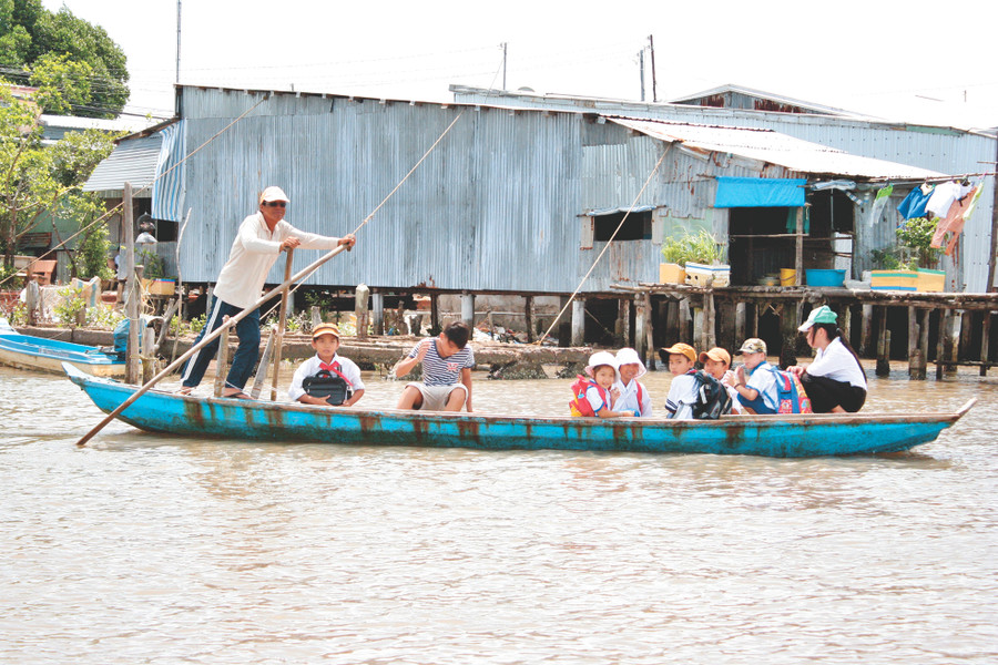 Ở miền Tây, ngoài đường bộ thì hàng ngàn học sinh phải đi xuồng, đi đò đến trường. Ảnh: Q. Ngữ