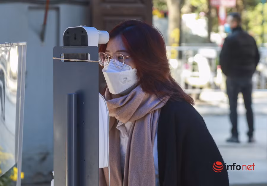 Trước khi vào chùa, du khách phải thực hiện nghiêm các quy định phòng tránh dịch Covid-19 như đeo khẩu trang, sát khuẩn tay và đo nhiệt độ. Ảnh: Infornet.