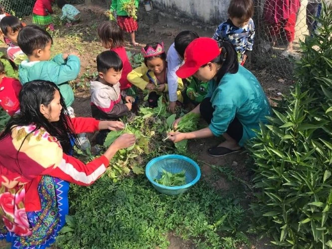 Cô Mỷ (ngoài cùng bên phải) cùng đám trò nhỏ nhặt rau, chuẩn bị cho bữa cơm trưa. Ảnh: Nhân vật cung cấp