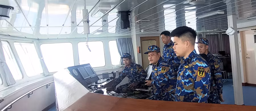 Thiếu tá Phan Tiến Định, thuyền trưởng tàu HQ 571 (thứ 2, hàng trên, từ phải qua) đang chỉ huy tàu thả neo gần quần đảo Song Tử Tây. Ảnh: Bình Thanh.