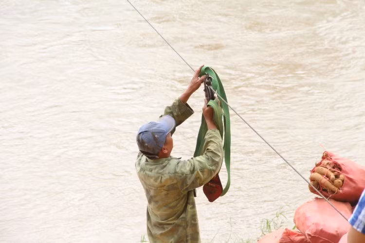 Mỗi gia đình tự sắm một cái ròng rọc với giá 300.000 – 400.000 đồng để đu cáp vượt sông.