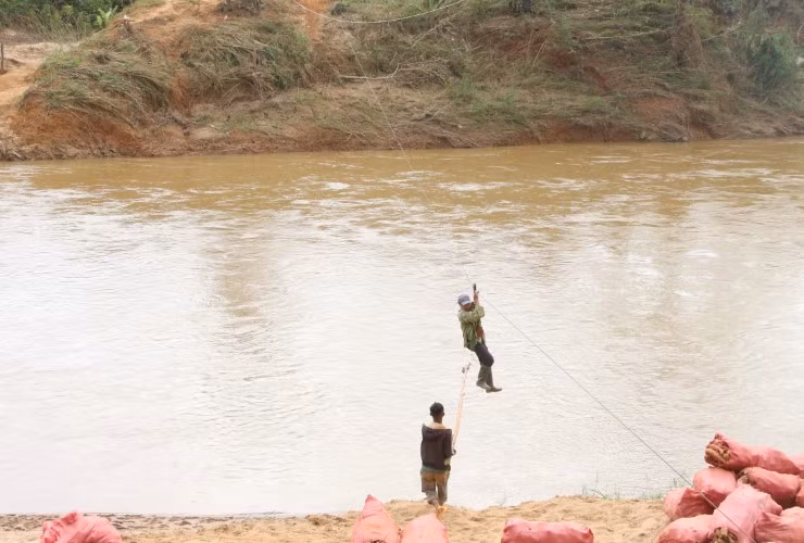 Cáp treo bị mắc kẹt, người dân dùng cây hỗ trợ, kéo nhau vào bờ.