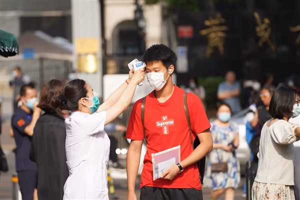Học sinh Trung Quốc đo thân nhiệt trước khi vào điểm thi đại học.
