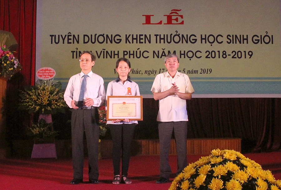 Ông Nguyễn Kim Khải và ông Phạm Quang Tuệ trao tặng Bằng khen của Bộ trưởng Bộ GD&ĐT cho em Hoàng Anh Phương – Giải Nhất quốc gia môn Hóa học. Ảnh: Việt Hà.