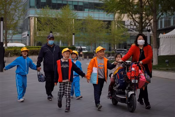 Phụ huynh đưa con đến trung tâm giáo dục tư nhân sau giờ học chính khóa.