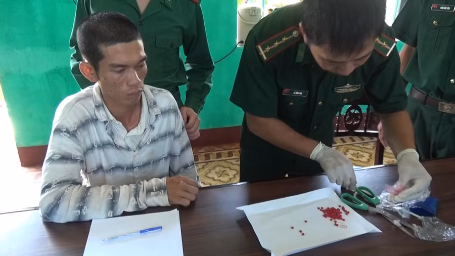 Kiểm đếm số ma túy tổng hợp thu được từ nhà đối tượng Mai Văn Tới (áo trắng kẻ ngang).